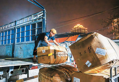 近日，在越南河内广霸花市，商贩将产自中国云南的鲜花从货车上搬运下来。新华社记者 朱 炜摄
