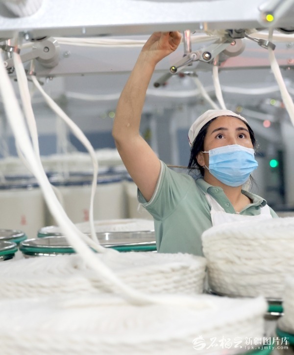 11月10日，喀什市长盛纺织科技有限公司工人在对接棉线。陈文军摄