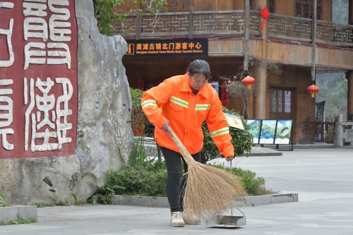 图为冉友琼在龚滩古镇北门广场打扫清洁。（受访者供图）