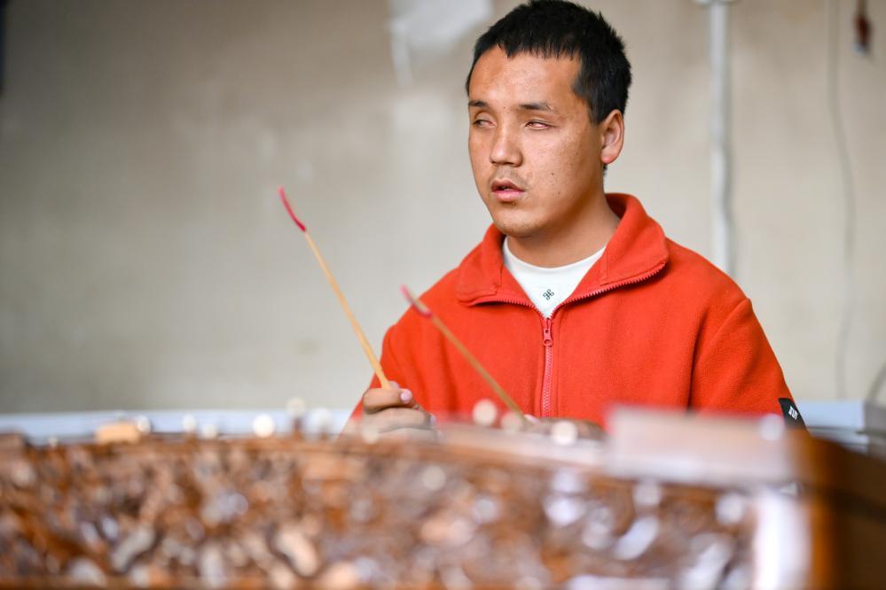 2025年10月11日，达瓦次仁在练习演奏扬琴。