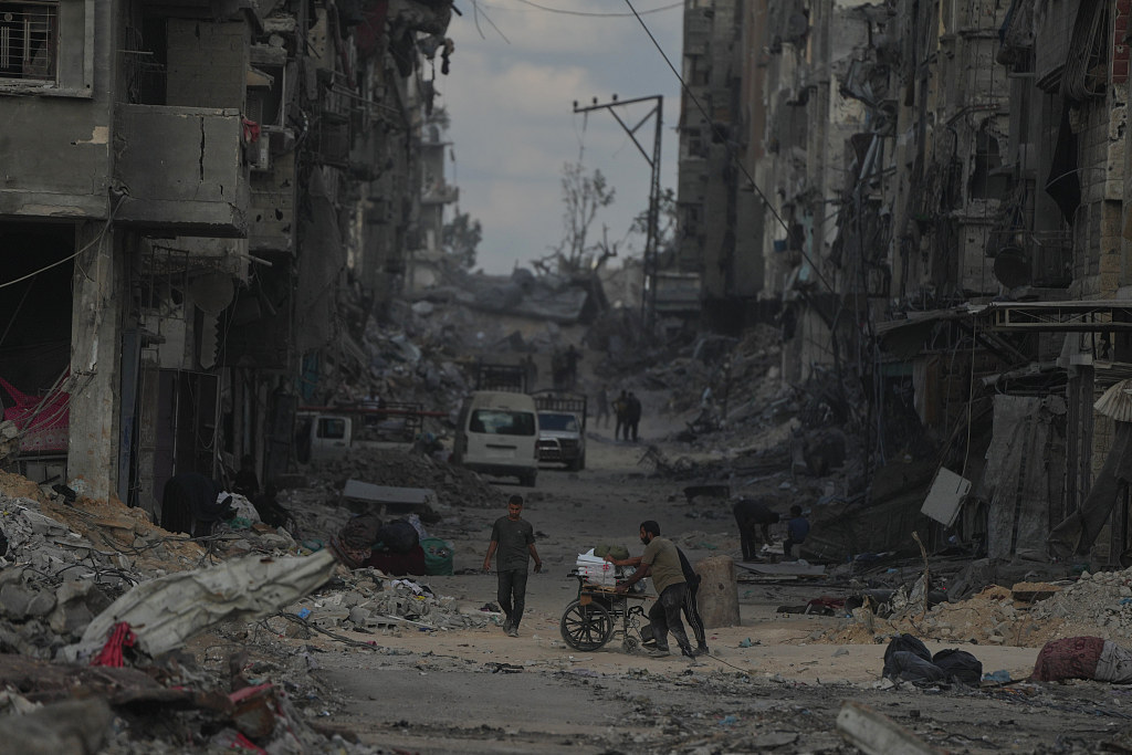 当地时间2025年10月12日,加沙城,以色列和哈马斯同意暂停战争并释放剩余人质后,巴勒斯坦人推着装载物品的手推车返回家园。视觉中国 图