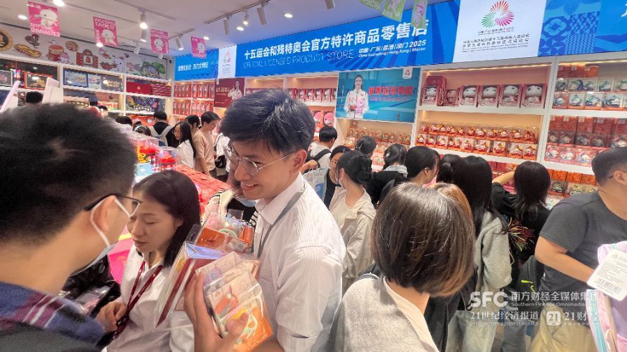 （在旗舰店内选购十五运会周边商品的人群挤得插不进脚，郑玮/摄）
