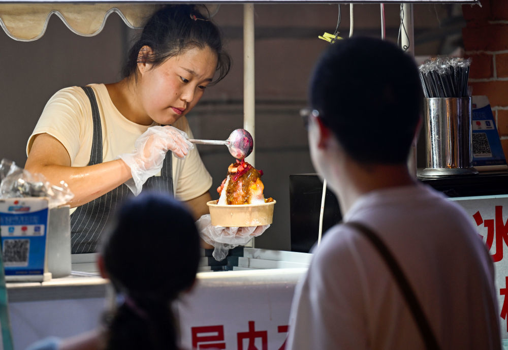在天津市南开区，一家街边商户正在制作刨冰。新华社记者 赵子硕 摄