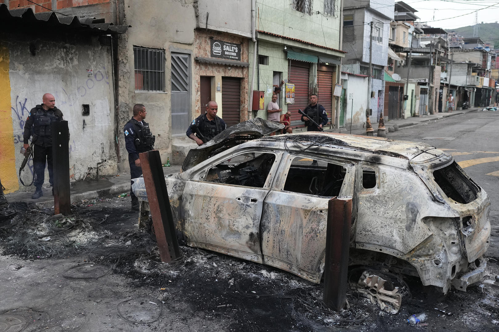 ▲10月28日,里约热内卢警察查看一辆被焚毁的汽车 图据视觉中国