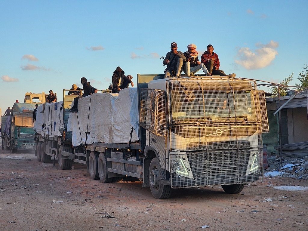 当地时间2025年10月12日,根据停火协议,载有人道主义援助物资和燃料的卡车通过凯雷姆沙洛姆口岸进入加沙地带,抵达汗尤尼斯。