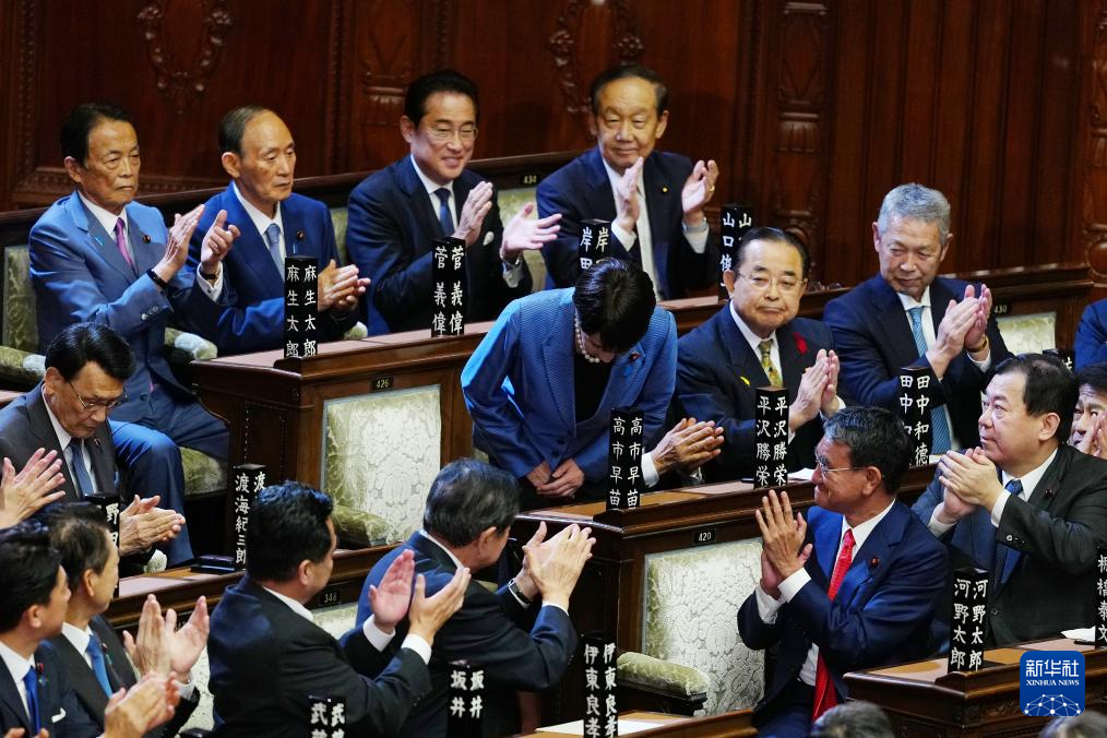 10月21日,在日本东京,自民党总裁高市早苗(中)在临时国会众议院首相指名选举中胜出后起身致谢。新华社记者 贾浩成 摄