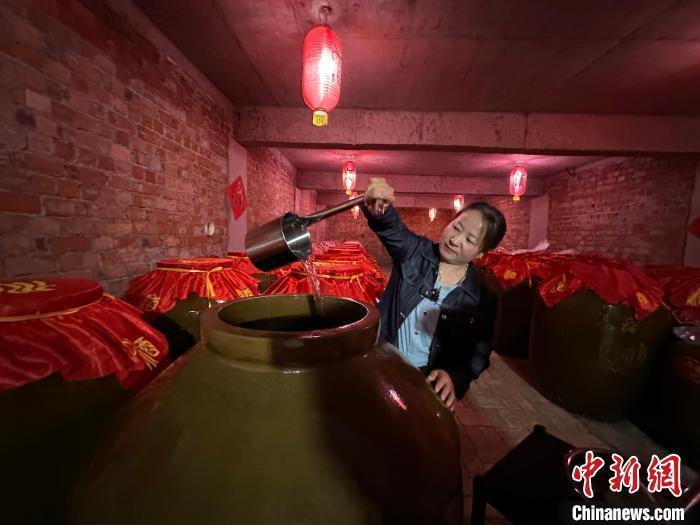 图为4月底，刘燕在自家“庭院式”生态酿酒作坊的酒窖里准备品酒。冯志军　摄