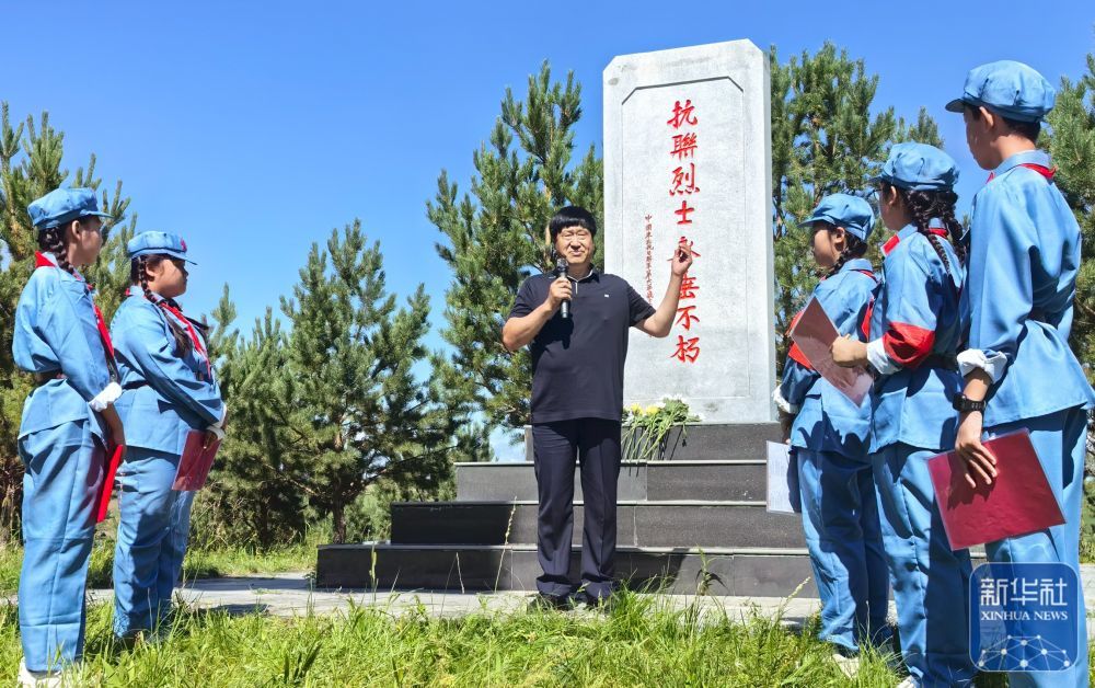 ↑8月14日,内蒙古呼伦贝尔市阿荣旗六合镇,孙福贵(中)在“红军岗”上向参加“重走抗联路”活动的学生讲述东北抗联的事迹。新华社发(刘振科摄)