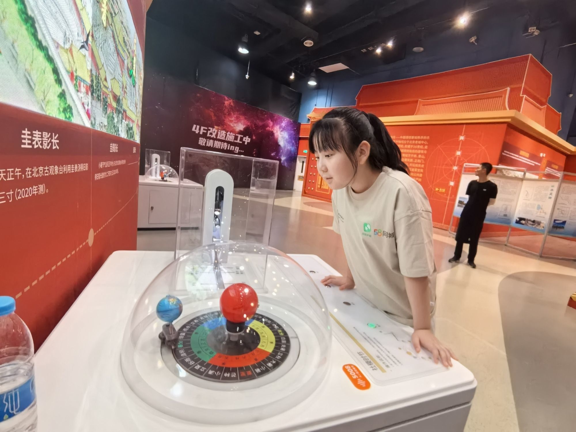 在“科技中轴”主题展区，小朋友正在观察二十四节气小表盘的四季变化。