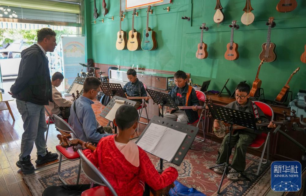 ↑ 9月13日，在拉萨市古乐扎念琴行，孩子们在弹奏扎念琴。