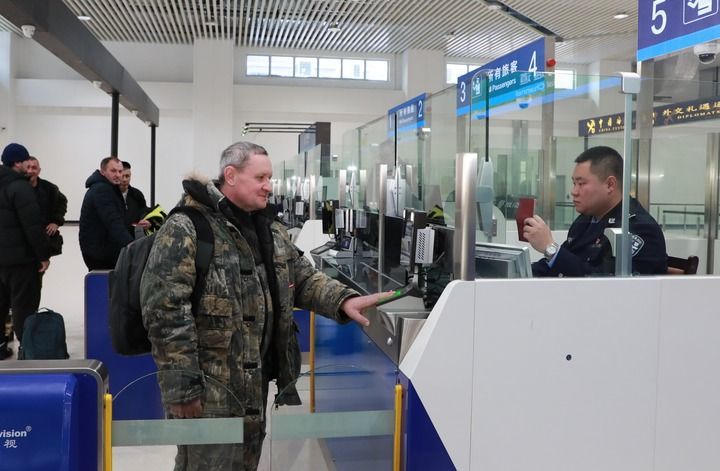 2024年12月10日,在黑河公路口岸旅检大厅,黑河出入境边防检查站民警为首班次客车入境旅客办理边检通关手续。当日,中国黑河公路口岸—俄罗斯卡尼库尔干公路口岸旅客运输正式开通。新华社发(刘松摄)