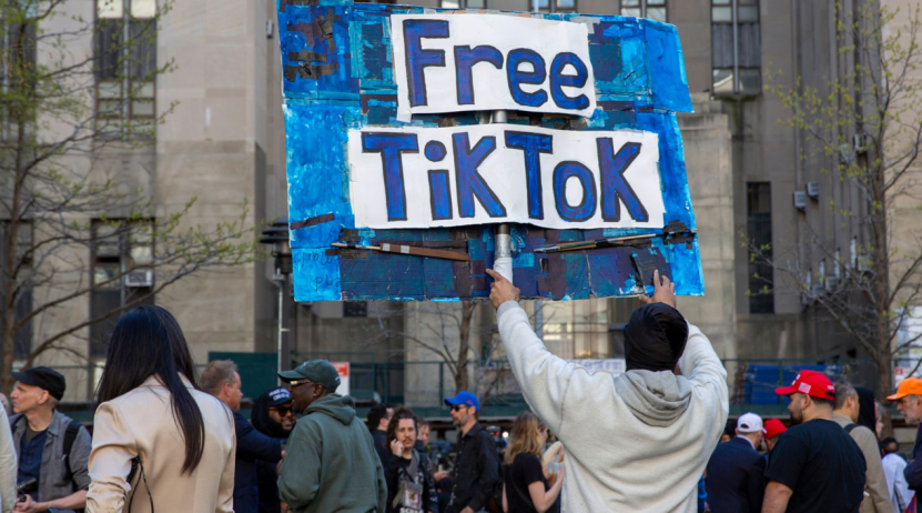 ◆2024年4月,拜登签署TikTok禁令时,一名男子举着“让TikTok自由”的牌子。