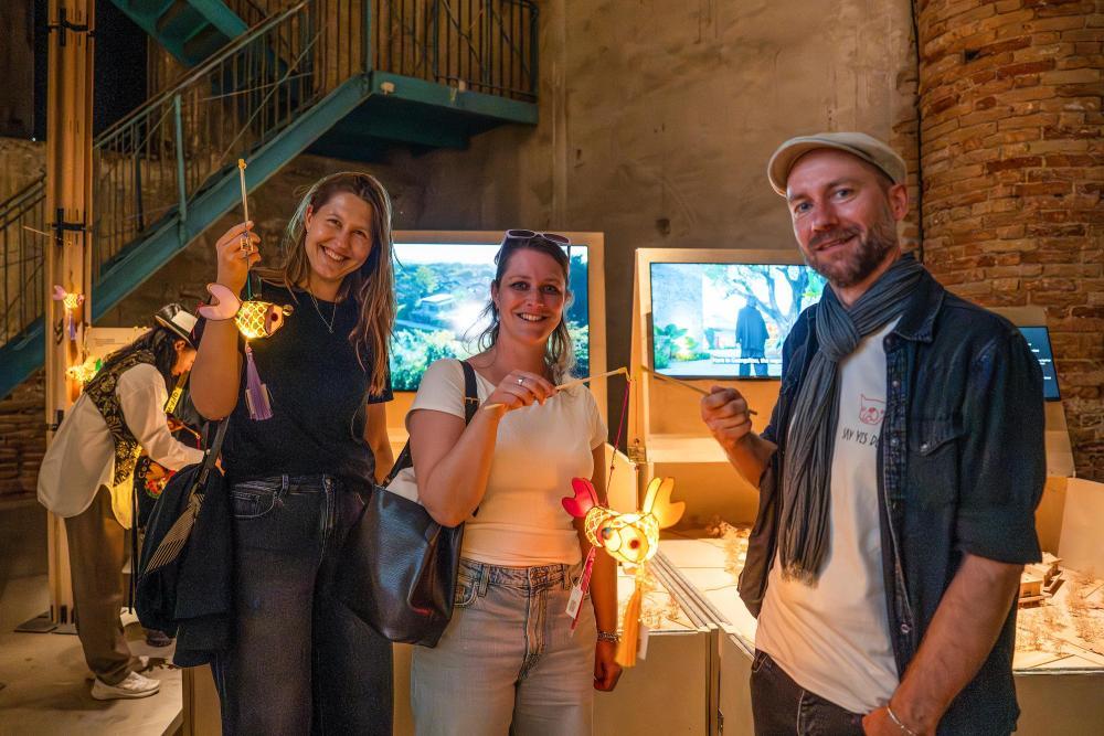 在意大利威尼斯,参观者在第19届威尼斯国际建筑双年展主题馆“塱头实验”展区展示现场领取的岭南鱼灯纪念品(2025年5月10日摄)。