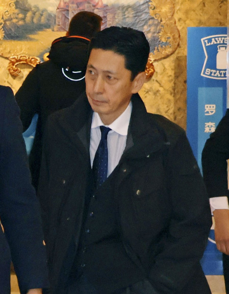 18日上午,金井正彰面色严肃,离开下榻酒店 图片转自日本共同社