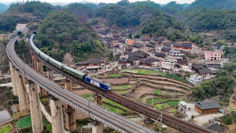 1月18日,，5640次列車駛過(guò)貴州省凱里市爐山鎮(zhèn)六個(gè)雞村（無(wú)人機(jī)照片）。新華社發(fā) （龍建睿攝）