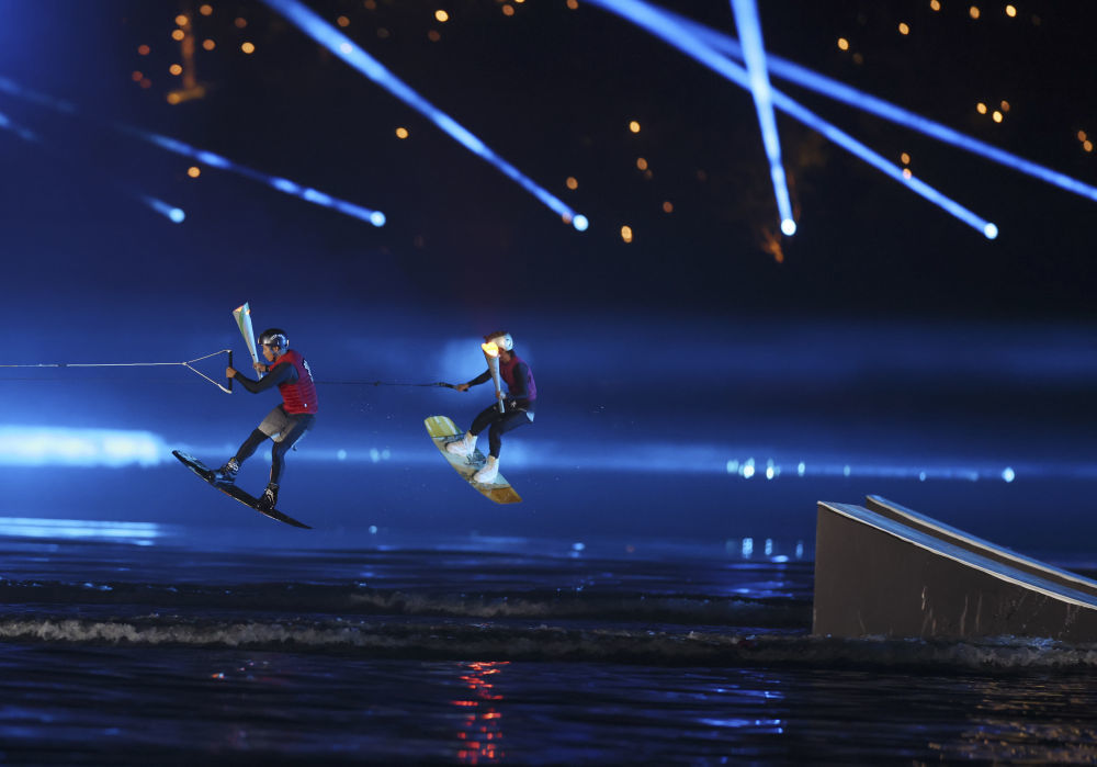 8月7日，火炬手徐露、阿卢晓波（左）在点火环节中。新华社记者 陈斌 摄