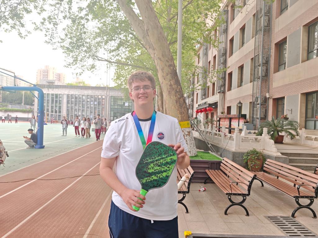 4月17日,美国高中生瑞安·詹姆斯·科克里在北京中学展示签名球拍。新华社记者陆君钰摄