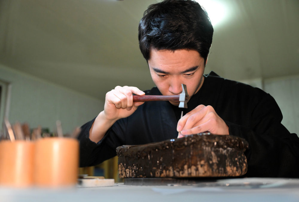 马赛在工作室内进行錾刻。新华社发