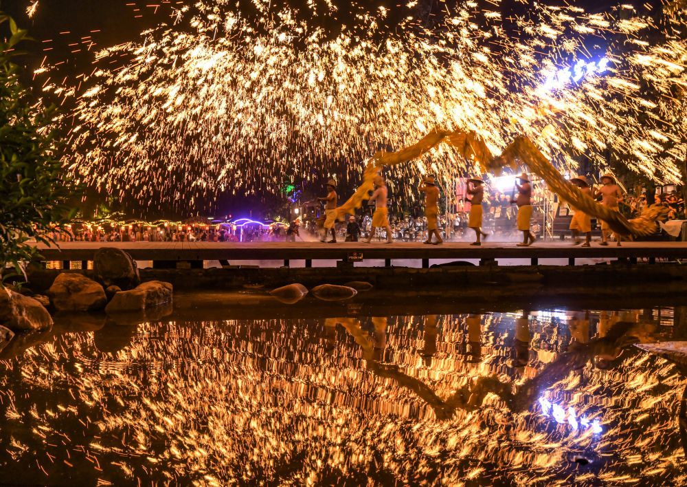 10月5日晚,在四川省成都市双流区黄龙溪古镇,民间艺人为游客表演非遗“火龙灯舞”。新华社发(李向雨摄)