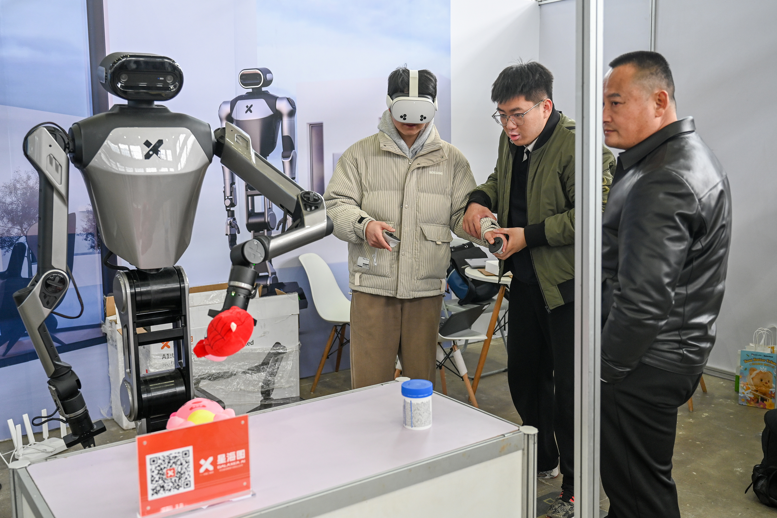 2025年2月22日,上海西岸艺术中心,观众在体验VR遥控机器人拿东西。澎湃新闻记者 朱伟辉 图