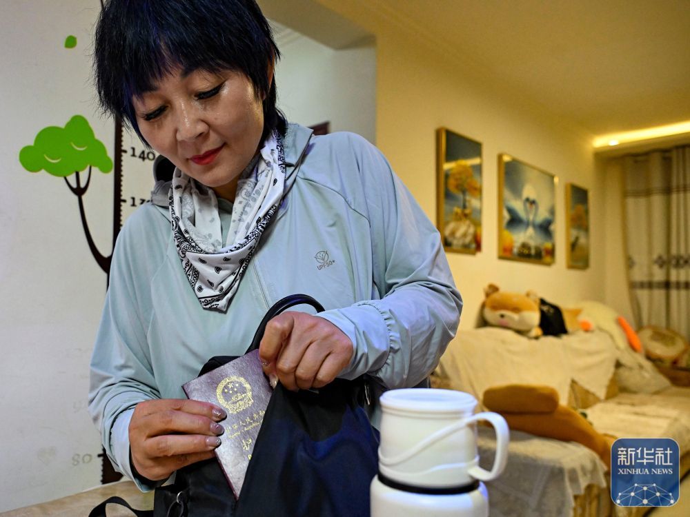 高云在执行运车任务前,在新疆霍尔果斯家中把护照装入背包中(6月9日摄)。