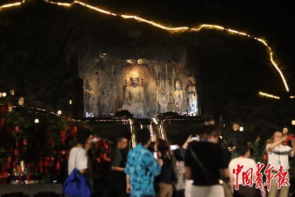 8月19日,河南洛阳,游客在东山观景台与伊河对岸西山石窟的卢舍那大佛合影。中青报·中青网记者 余冰玥/摄