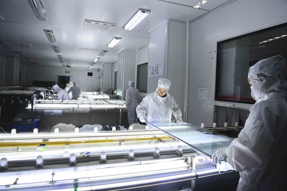 在位于广西北海市铁山港（临海）工业区内的一家玻璃生产企业，工作人员对玻璃半成品进行加工处理（2025年3月摄）。新华社记者 曹祎铭 摄