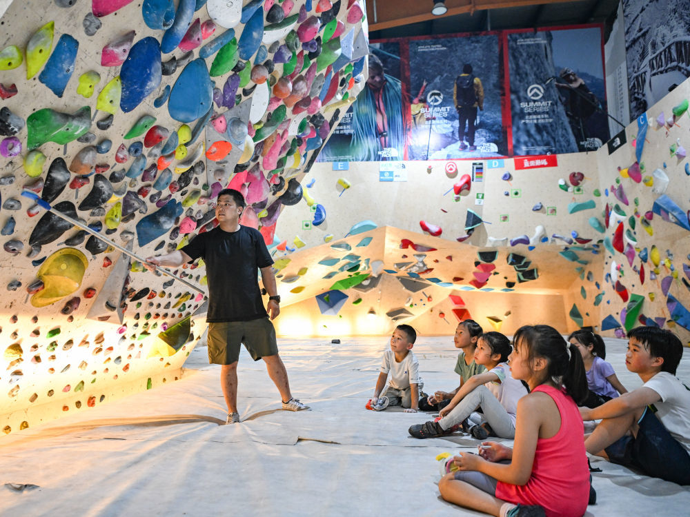 在四川省成都市一家攀岩馆内，一位攀岩教练在指导孩子们攀岩技巧（2024年7月15日摄）。新华社记者 王曦 摄