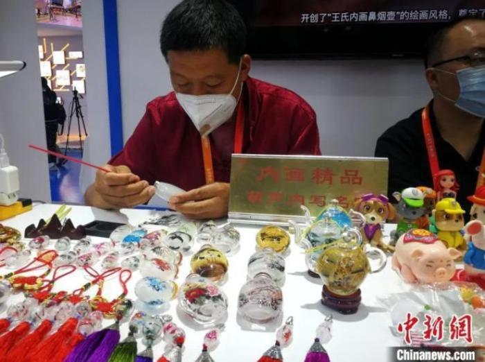 图为天津内画鼻烟壶代表性传承人在展会现场制作内画鼻烟壶。张道正摄