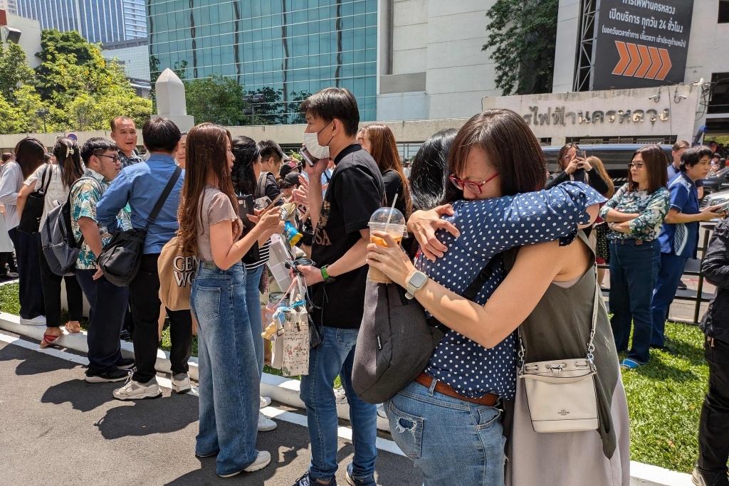 当地时间3月28日,泰国曼谷,居民们冲出建筑物,涌向街道。