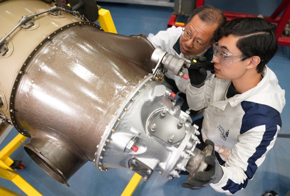 在香港专业教育学院,黄富东(右)在检查涡轮螺旋桨飞机引擎(1月14日摄)。新华社发(王申摄)