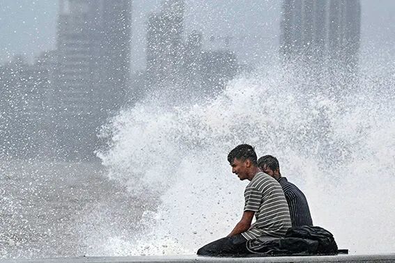 2023年7月6日,一些年轻人在印度孟买的海边戏浪纳凉