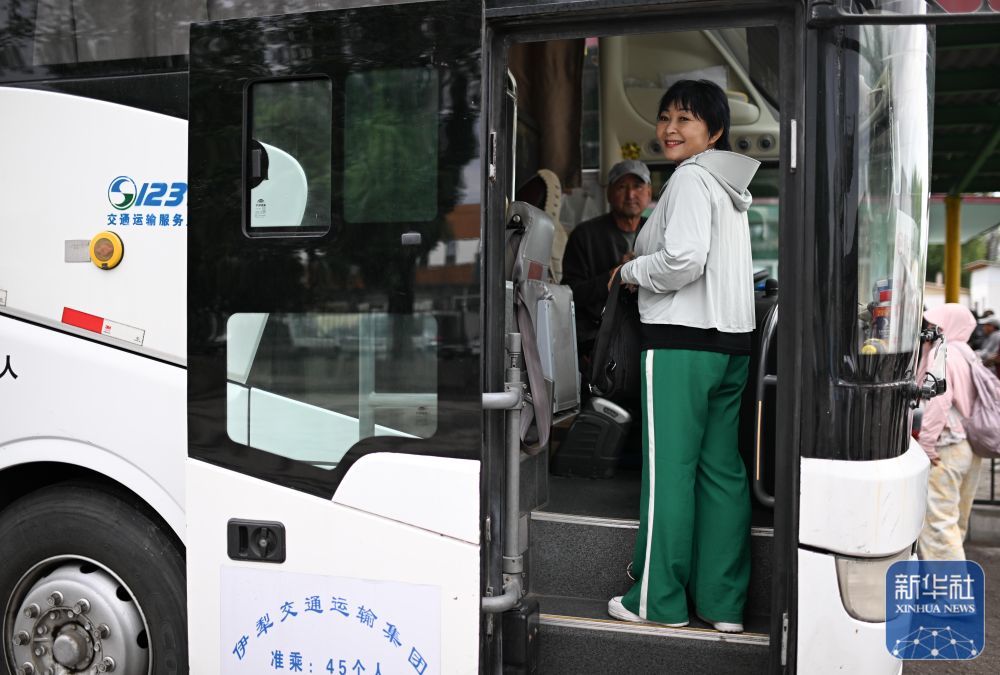 清晨,“摆渡人”高云在哈萨克斯坦扎尔肯特镇汽车站登上跨国客运大巴,准备返回中国(5月24日摄)。
