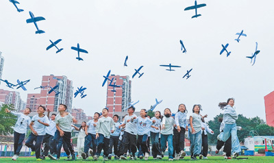 江苏省宿迁市泗洪县新星城西学校,学生们在放飞飞机模型。李 佳摄(影像中国)