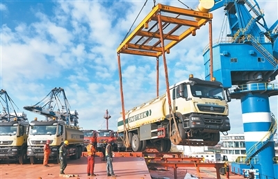 十二月八日,国产卡车在山东港口烟台港装船出口。