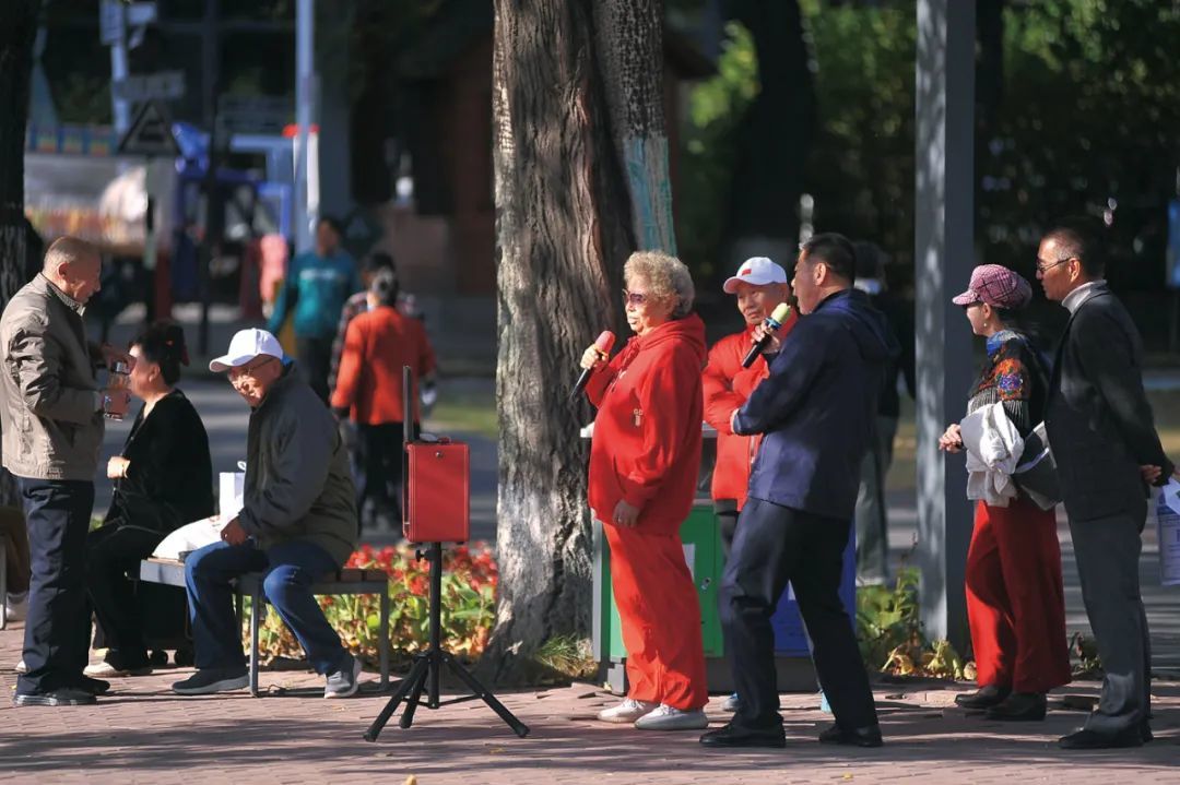 2024年10月11日，黑龙江哈尔滨。老人们在公园唱歌、锻炼身体。（图 / 视觉中国）