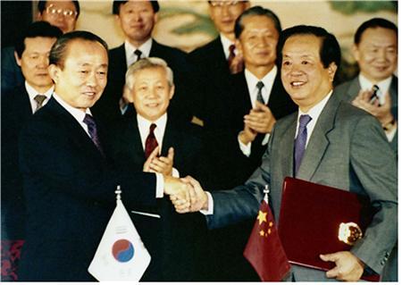 1992年8月24日,钱其琛(右)与韩国外长李相玉在北京钓鱼台国宾馆正式签署中韩建交公报。