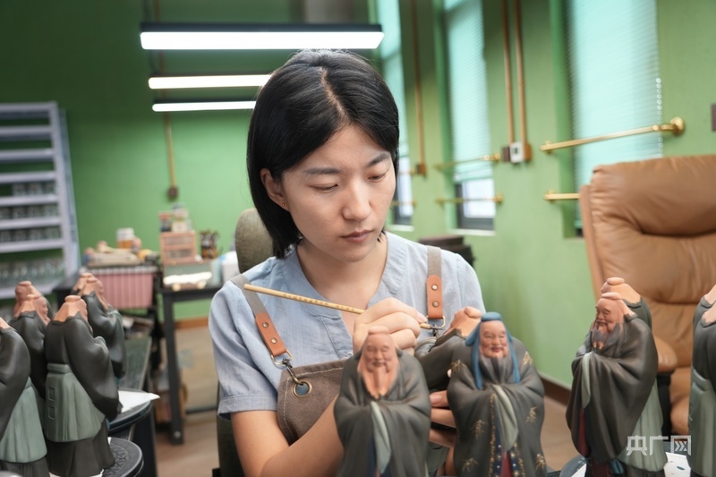 郑茹月正在制作泥塑(央广网记者 周思杨 摄)