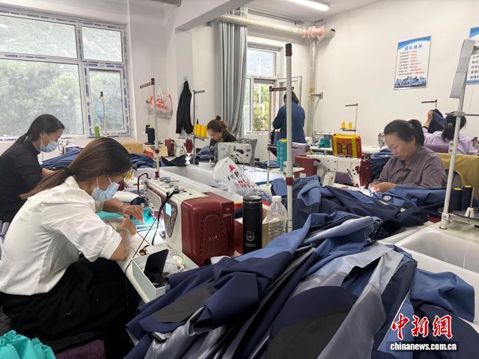 图为环县苏泰服饰有限公司的生产车间一片忙碌景象　杨娜　摄