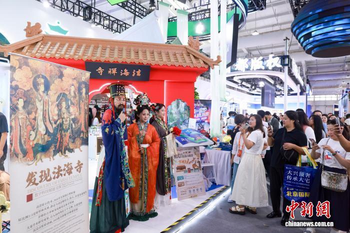 9月12日，在北京举行的2025年中国国际服务贸易交易会上，中国传统文化相关内容吸引观众的目光。图为数字科技赋能的文保项目《发现法海寺》的展台上，身着汉服的工作人员吸引观众。　中新社记者 贾天勇 摄