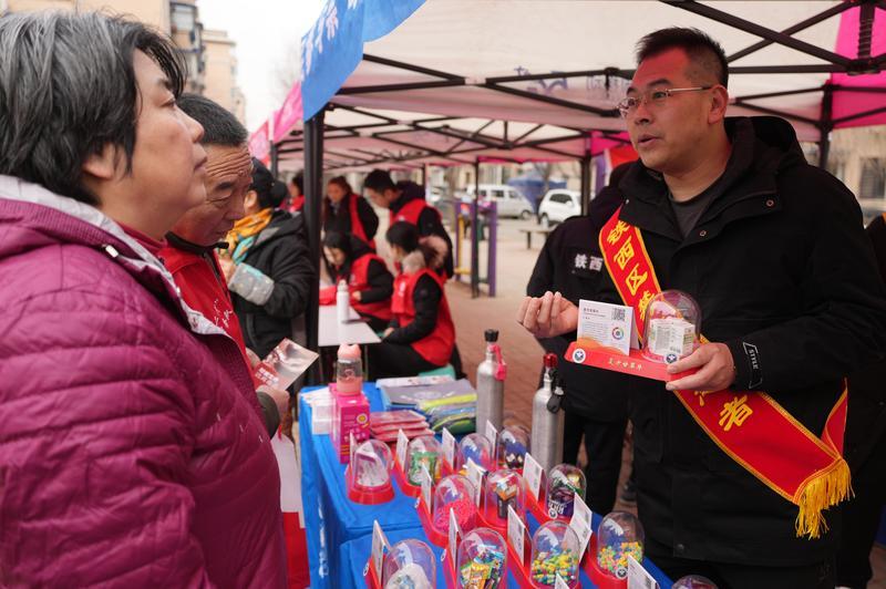 在沈阳市铁西区重工新村社区广场,志愿者提醒居民远离药物滥用。新华社资料图