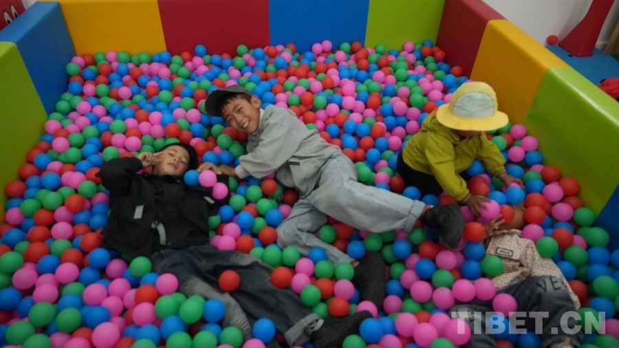 图为小孩儿们在幸福驿站托幼室玩耍