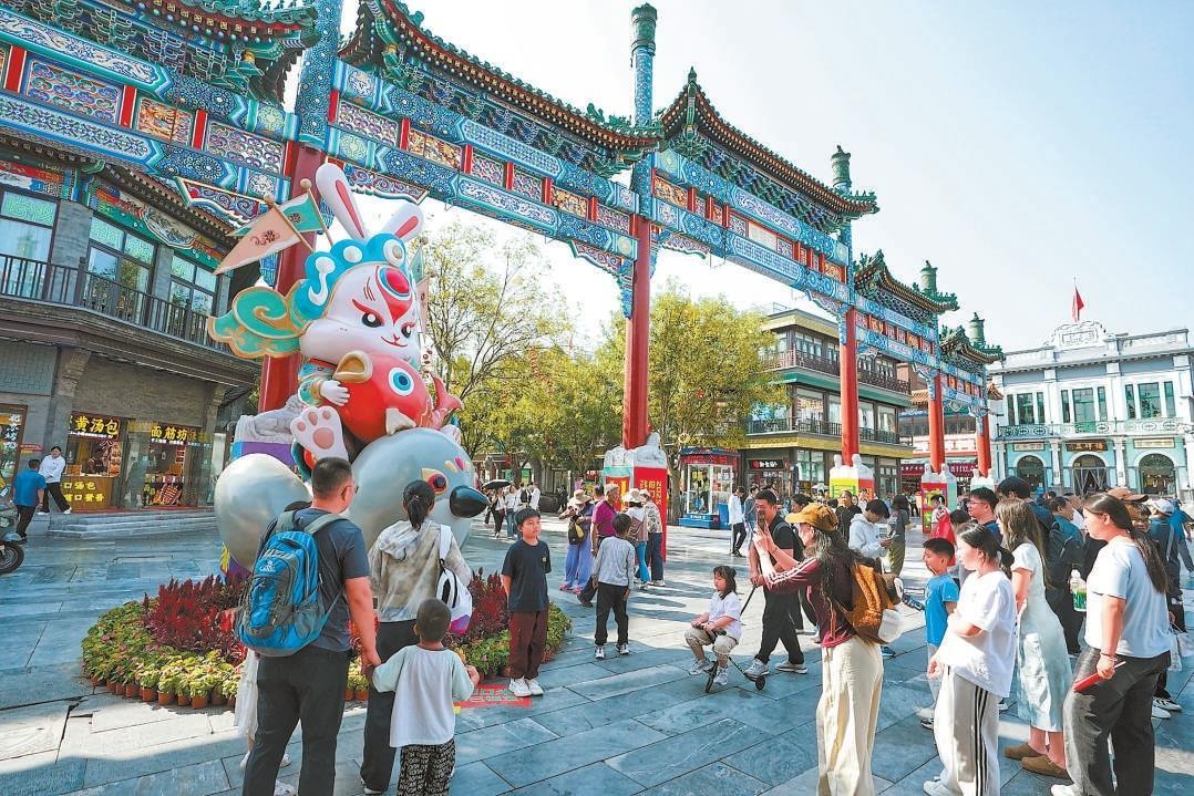 △双节假期，北京前门商业步行街游人如织，市民游客逛潮闪节、打卡“前门·中华美食荟”，感受中轴线的魅力。