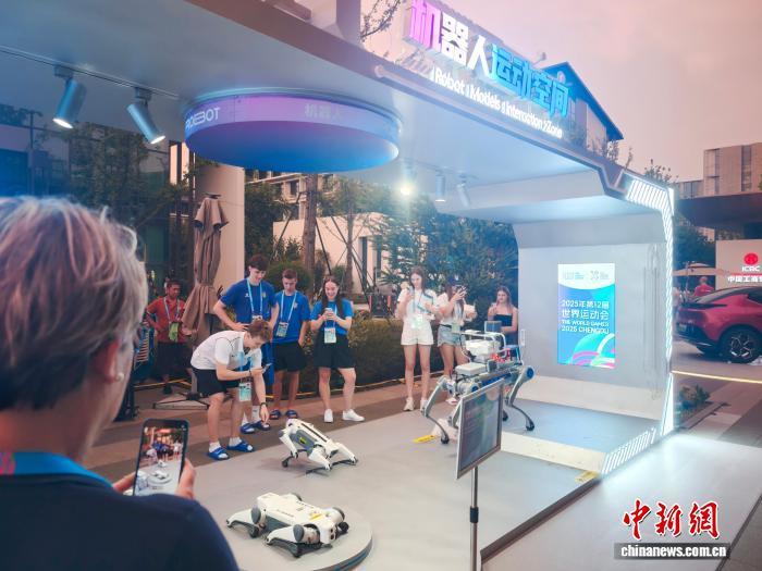 世运村内,机器狗人气颇高。图为一名外国运动员正与机器狗握手。(成都市科技局供图)