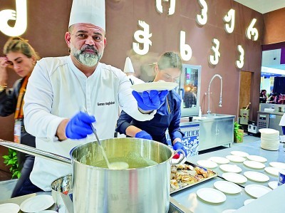 第八届中国国际进口博览会格鲁吉亚展厅，展商与游客分享当地美食。本报记者 范天培摄/光明图片