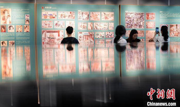图为观众参观“万象人间”展区内描绘敦煌日常生活的壁画复制品展板　中新网记者　侯宇　摄