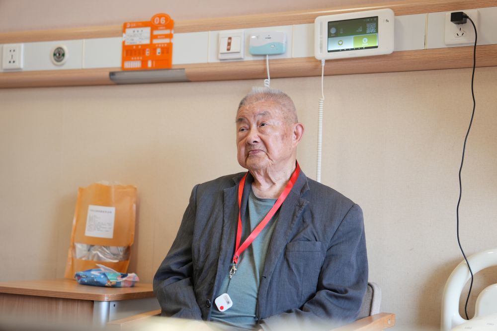 4月8日,在江苏无锡滨湖区一养老院,老人坐在房间里休息。他身后的“智慧床头机”可以把他的呼吸、心率信息实时传送到护士站。