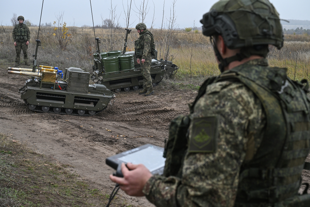 当地时间2025年11月10日,俄罗斯顿涅茨克地区,俄罗斯中央集团军的辐射、化学和生物防御部队的军人在操作“信使”地面机器人。视觉中国 图