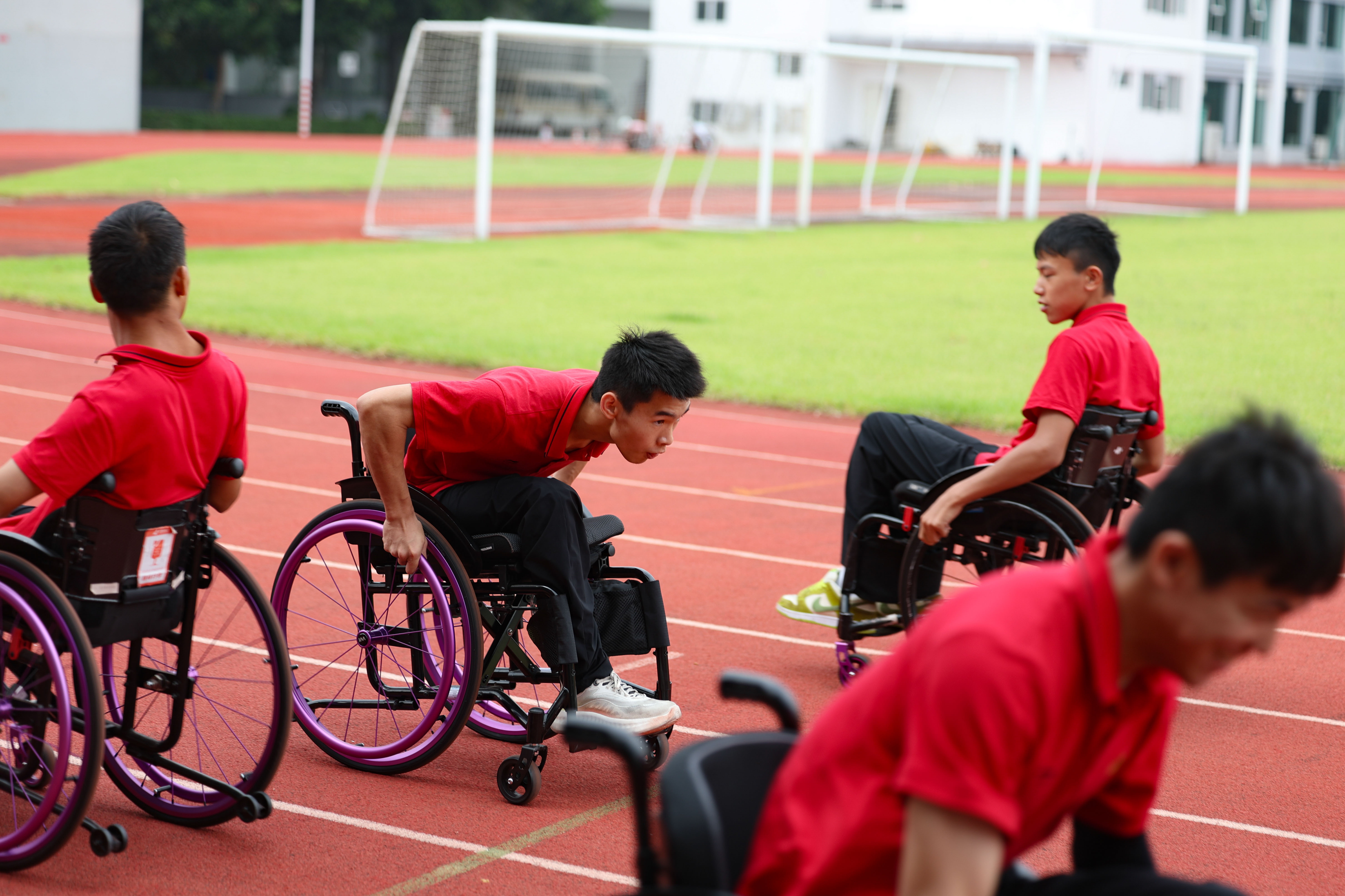 日常训练中，轮椅击剑队员们在体育场上以折返跑的方式锻炼体能。