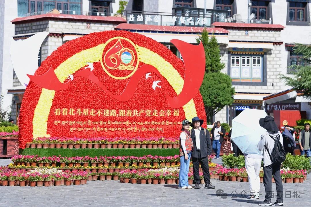 图为游客在拉萨大昭寺广场上的大庆宣传标语前合影留念。记者 白玛泽旺 摄